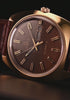 TW2Y87200 Close-up views of the Timex 1978 Day Date Fumé Reissue highlighting its gold-tone case, brown gradient dial, day-date window, and brown leather strap.