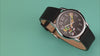 TW2Y99300 Rotating views of the Marvin the Martian x Timex Easy Reader® watch, highlighting its starry character dial, silver-tone case, and black leather strap against green and red backgrounds.