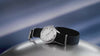 Timex Marlin Jet Automatic watch rotating on display, showcasing its silver-tone dial, domed crystal, navy woven strap, and polished stainless-steel case.