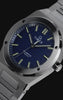 Close-up video of the stainless-steel Q Timex Marbella watch, highlighting its deep blue textured dial, luminous markers, polished bezel, and integrated bracelet against a dark background.