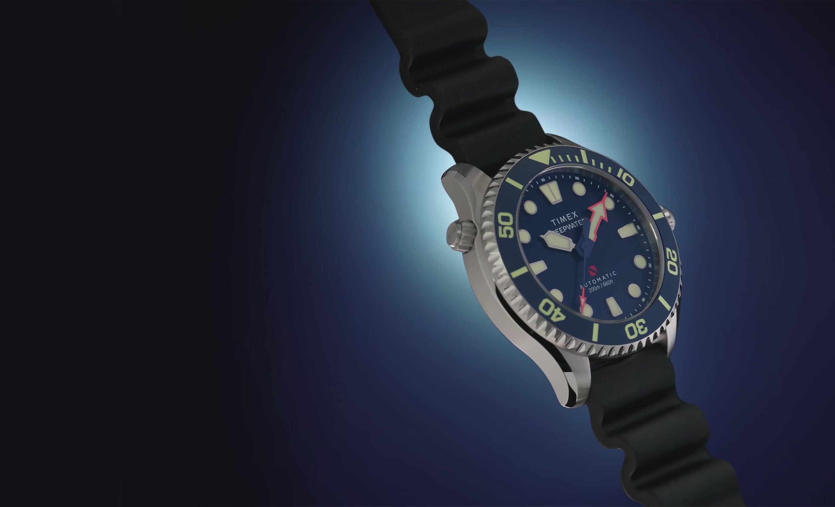 Deepwater Meridian 200 HEV Automatic watch rotating against a dark blue background, showcasing its blue dial, dive bezel, stainless-steel case, and black rubber strap.