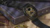 TW2Y76000 Moving close-ups of the black watch on Harry Potter-themed books, highlighting its gold hourglass dial and star details.