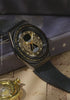 TW2Y76000 Moving close-ups of the black watch on Harry Potter-themed books, highlighting its gold hourglass dial and star details.