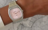 Timex Automatic 1983 E Line watch with a pink dial and stainless steel bracelet worn on the wrist.
