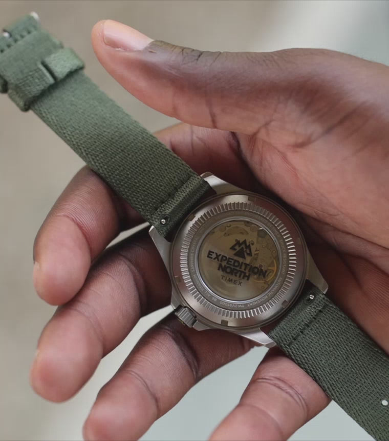 This is a video that shows Expedition North Titanium Automatic which features a recycled nylon strap.  The video also shows forestry scenery clips with bright sunbeams flowing through the pines.